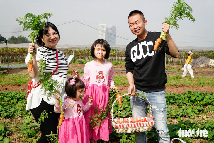 Gia đình chị Trương Thanh Loan (TP Bắc Ninh) tranh thủ nghỉ lễ đưa các bạn nhỏ đi cho thú ăn, nhổ cà rốt - Ảnh: NGUYỄN HIỀN