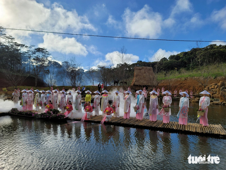 Các nghệ sĩ, người mẫu, học sinh trình diễn áo dài bên hồ Đam Bri - Ảnh: TRẦN HƯỚNG