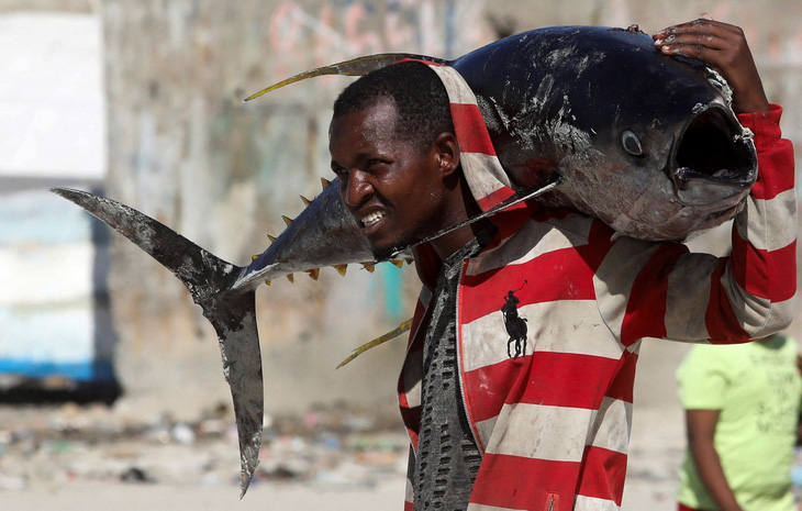 Người đàn ông mang vác trên vai một con cá lớn ở bãi biển Liido, thủ đô Mogadishu của Somalia trong ảnh chụp ngày 29-12 - Ảnh: REUTERS