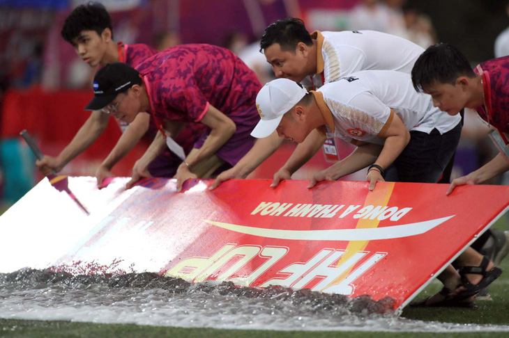 Ban tổ chức đẩy nước ra sân để trận chung kết có thể bắt đầu - Ảnh: VIÊN LÊ
