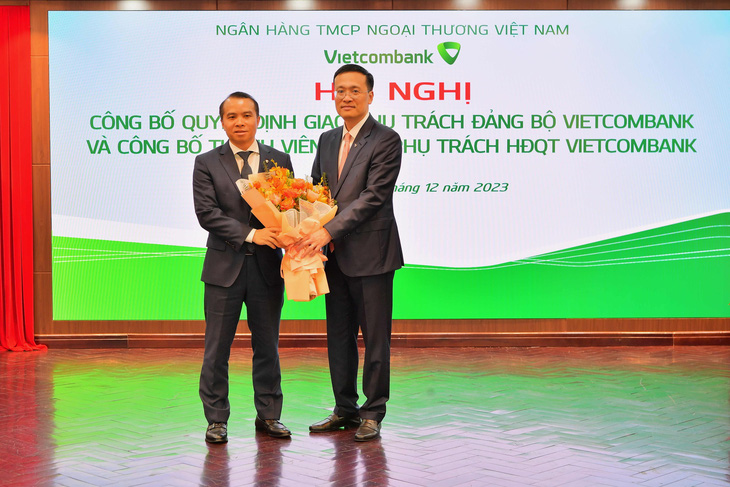 Ông Phạm Quang Dũng - Bí thư Đảng ủy, Chủ tịch HĐQT Vietcombank (bên phải) - tặng hoa chúc mừng ông Đỗ Việt Hùng - Ảnh: VCB
