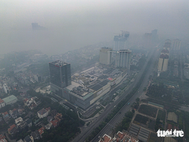 Nhà cao tầng ở Hà Nội biến mất trong làn sương mù cùng bụi mịn - Ảnh: HỒNG QUANG 