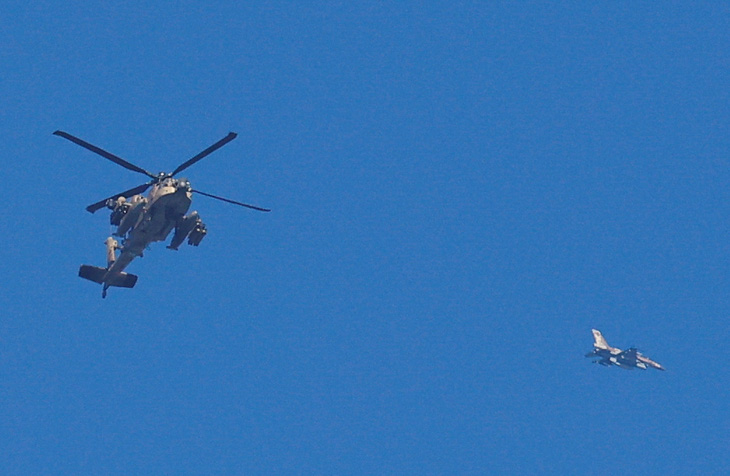 Một chiếc trực thăng Apache của quân đội Israel và một máy bay khác bay gần dải Gaza sau khi lệnh ngừng bắn tạm thời giữa Israel và Hamas kết thúc. Ảnh chụp từ miền nam Israel ngày 3-12 - Ảnh: REUTERS