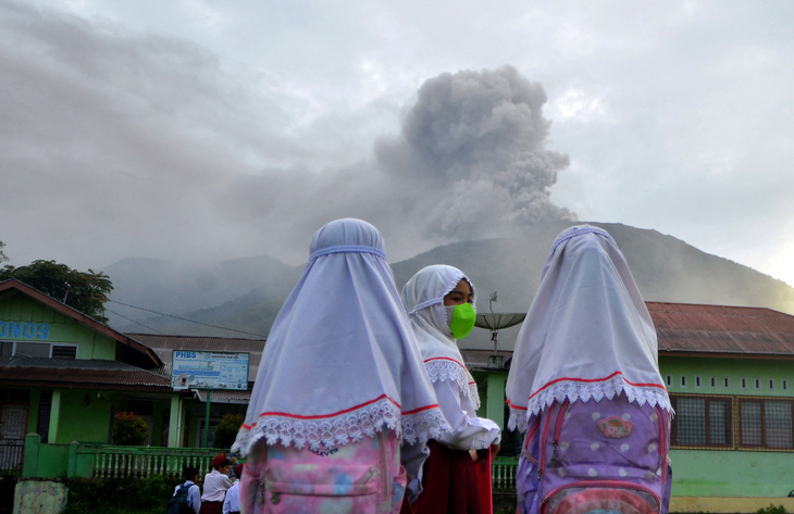 Người dân quan sát núi lửa Marapi phun trào ở tỉnh Tây Sumatra, Indonesia, sáng 4-12 - Ảnh: REUTERS