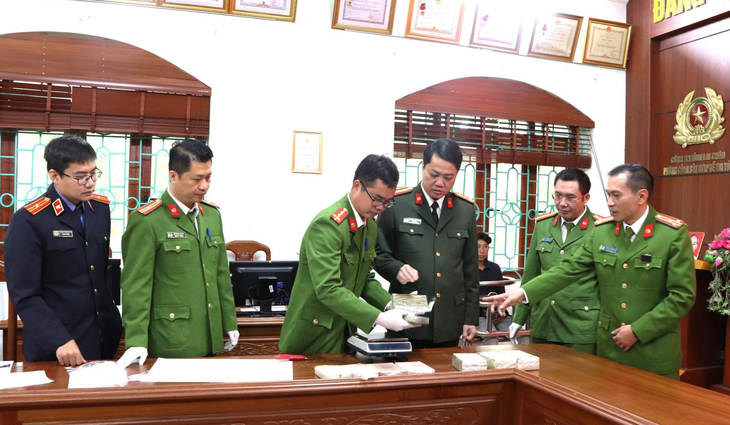 Đại tá Nguyễn Viết Giang - giám đốc Công an tỉnh - và lực lượng chức năng kiểm tra ma túy thu giữ của Cứ A Hàng - Ảnh: Công an tỉnh Lai Châu