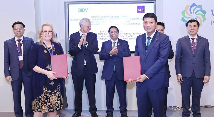 Tổng Giám đốc BIDV và bà Suzanne Gaboury - Vụ trưởng Vụ nghiệp vụ Khu vực tư nhân của ADB trao Bản ghi nhớ hợp tác về thúc đẩy tín dụng xanh, tài chính bền vững - Ảnh: BIDV