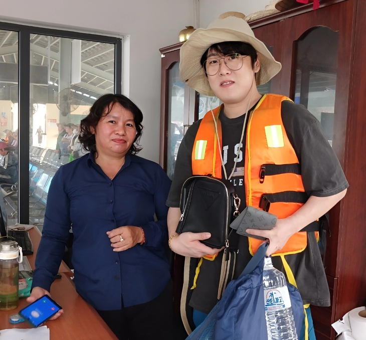 Nam du khách Hàn Quốc nhận lại túi và số tiền từ chị Quỳnh - Ảnh: BQL bến tàu du lịch Nha Trang