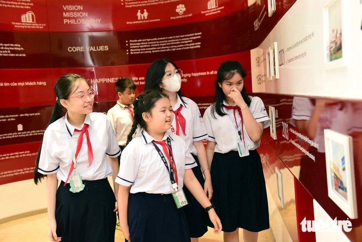 Các em học sinh tuy khác lớp nhưng với mong muốn tăng thêm kiến thức đã cùng nhau tìm hiểu về lịch sử hình thành của công ty Acecook Việt Nam - Ảnh: DUYÊN PHAN