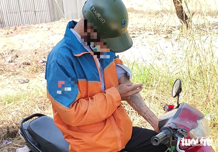 Nam thanh niên dừng xe máy tại lối mòn trong nghĩa trang Bình Hưng Hòa rồi lấy kim tiêm ra chích ma túy vào sáng 28-11 - Ảnh: MINH HÒA