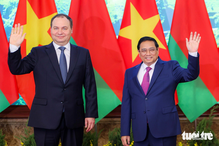 Thủ tướng Phạm Minh Chính và Thủ tướng Belarus Roman Golovchenko vẫy tay chào báo chí trước khi bước vào hội đàm - Ảnh: NGUYỄN KHÁNH