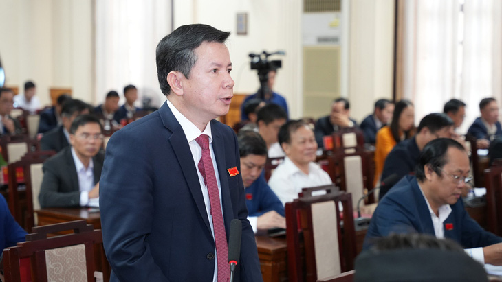 Ông Nguyễn Tân - giám đốc Sở GD&ĐT Thừa Thiên Huế - trả lời chất vấn về việc miễn 100% học phí - Ảnh: NGỌC HIỂU