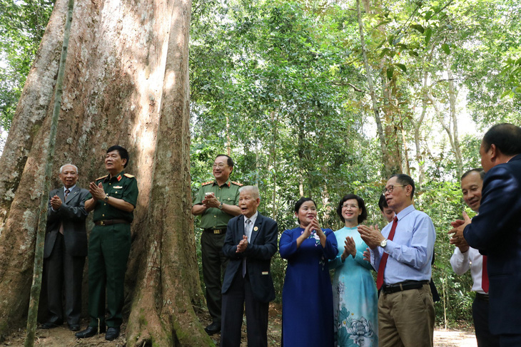 Các đại biểu tham quan, chụp lưu niệm ở quần thể 162 Cây di sản Việt Nam tại tiểu khu 379, rừng Mã Đà, nơi có cây kơ nia 1.230 tuổi - Ảnh: AN BÌNH