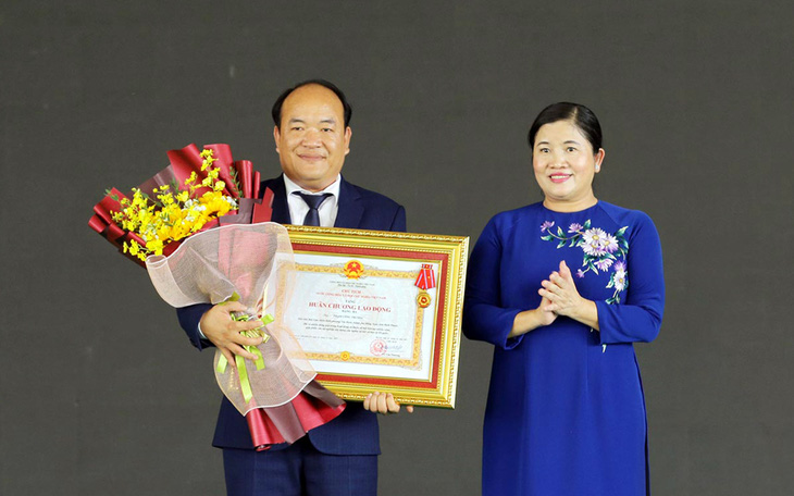 Ông Phạm Hương Sơn thừa ủy quyền của ông Phạm Công Trường nhận Huân chương Lao động hạng ba của Chủ tịch nước - Ảnh: NAM HÀ