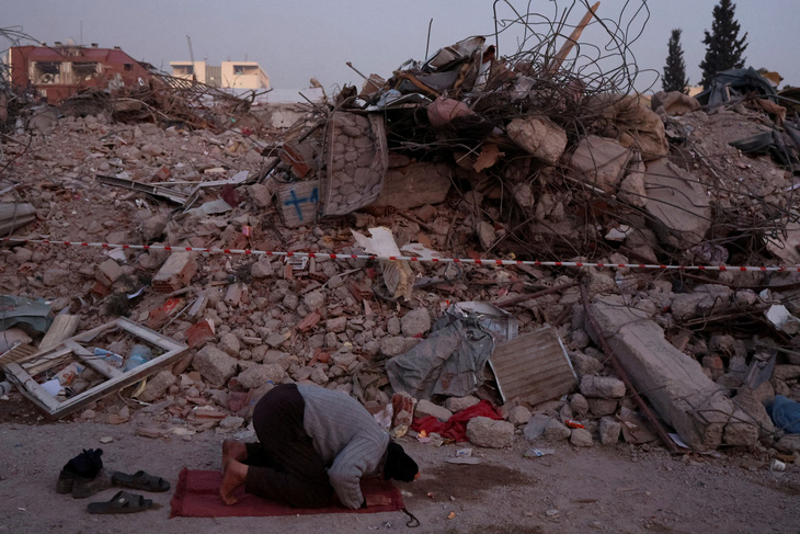 Một người đàn ông cầu nguyện gần đống đổ nát của những ngôi nhà bị phá hủy sau trận động đất chết người ở Kahramanmaras, Thổ Nhĩ Kỳ, ngày 14-2 - Ảnh: REUTERS