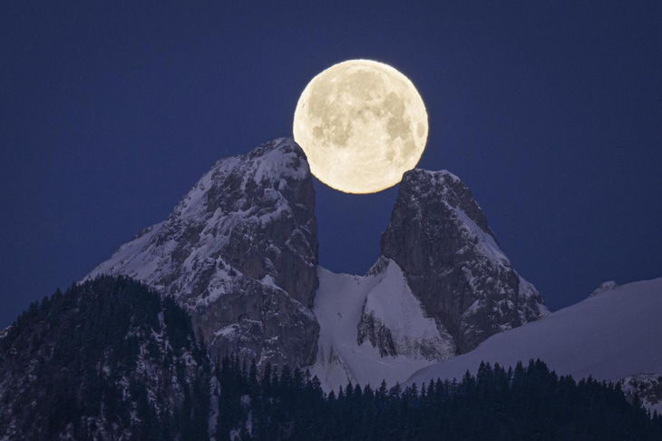Tay máy Anthony Anex đã chớp được góc ảnh thật thú vị: Mặt trăng tròn vành vạnh hiện lên sau đỉnh núi đôi Les Jumelles, gần Aigle, Thụy Sĩ, trông như nó được “gá” vào giữa hai đỉnh núi ấy