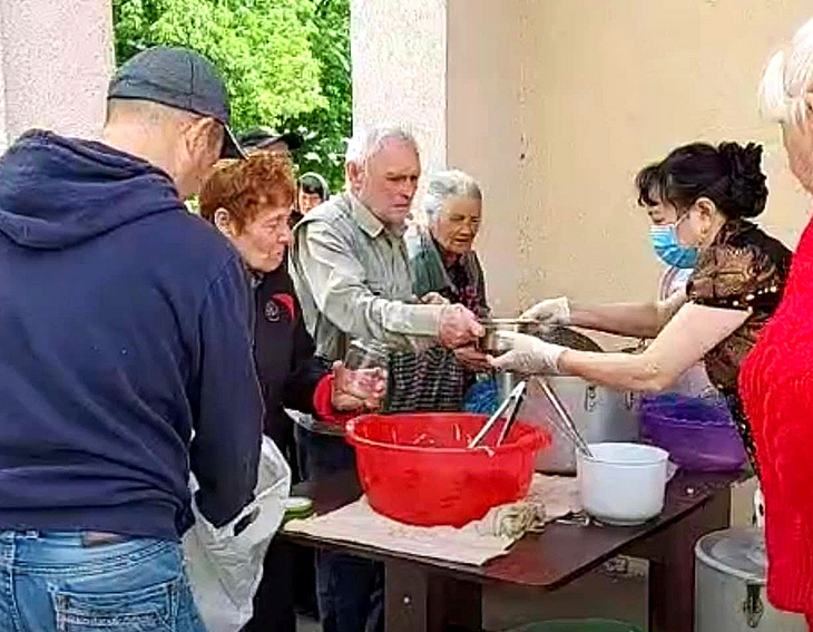 Bà Nguyễn Ngần nấu cơm cho cộng đồng ở Ukraine trong chiến sự và các túi quà từ tiền đóng góp của cộng đồng gửi đến vợ chồng bà Ngần để mua thực phẩm năm mới cho người dân khó khăn ở Kharkov - Ảnh: NVCC