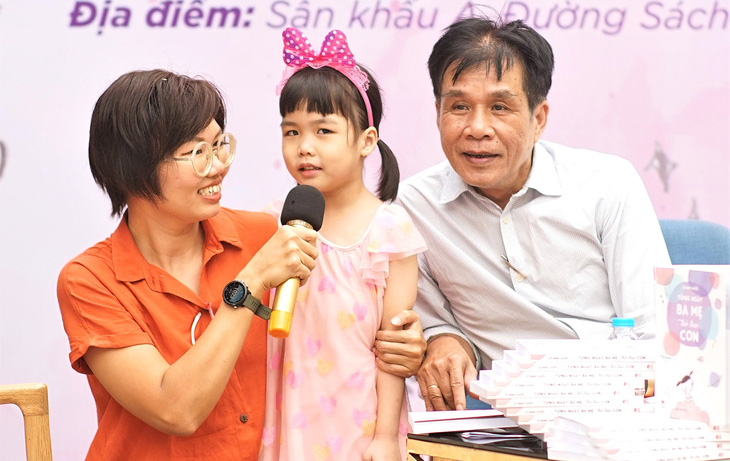 Nhà thơ Lê Minh Quốc cùng vợ và con gái Coco Mì tại buổi ra mắt sách Từng ngày ba mẹ thở theo con - Ảnh: HUỲNH VY