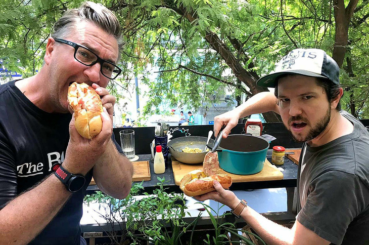 Matthew Cowan (trái) trải nghiệm bánh mì - món ăn nổi tiếng của Việt Nam - Ảnh: NVCC