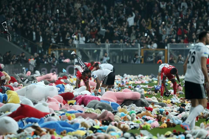 Các cầu thủ bóng đá nhặt đồ chơi, phần lớn là thú nhồi bông, do người hâm mộ ném xuống sân vận động bóng đá ở Istanbul, Thổ Nhĩ Kỳ hôm 26-2. Các đồ chơi này dành quyên tặng cho các trẻ em bị ảnh hưởng bởi trận động đất kinh hoàng đầu tháng này. Ảnh: AFP