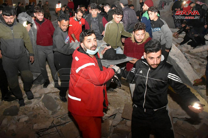Giải cứu người bị thương ở Syria, nơi một tòa nhà bị sập do động đất - Ảnh: AFP