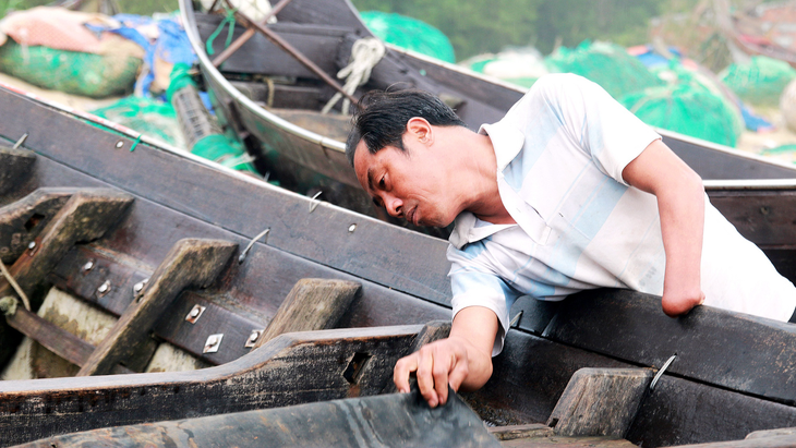 Ngư dân Trần Ngọc Sơn chỉ một tay vẫn can trường với nghề biển - Ảnh: NHẬT LINH