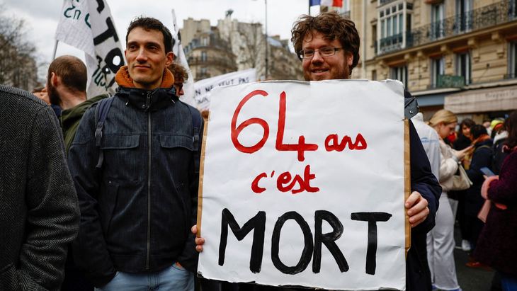 Người biểu tình ở thủ đô Paris với áp phích “Về hưu tuổi 64 là chết ngắc” - Ảnh: Reuters