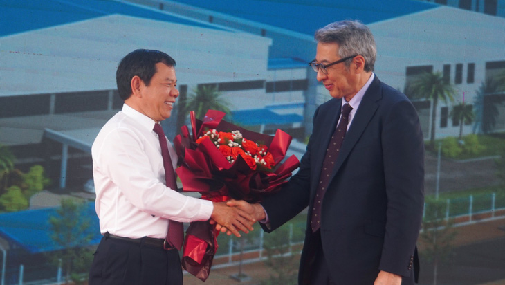 Ông Đặng Văn Minh, quản trị Ủy Ban Nhân Dân tỉnh Tỉnh Quảng Ngãi (trái) trao hoa chúc mừng doanh nghiệp Sumida khánh trở nên xí nghiệp sản xuất - Ảnh: TRẦN MAI