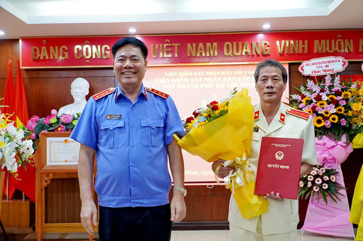 Phó viện trưởng Viện Kiểm sát nhân dân tối cao Nguyễn Quang Dũng (bên trái) trao quyết định cho ông Lê Xuân Hải - Ảnh: N.N.