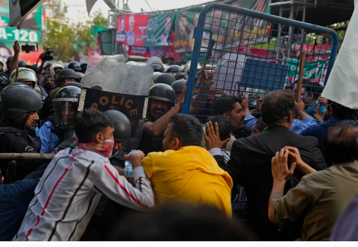 Những người ủng hộ cựu thủ tướng Imran Khan đụng độ với cảnh sát chống bạo động bên ngoài nhà riêng của chính trị gia này ở Lahore, Pakistan ngày 14-3 - Ảnh: AP