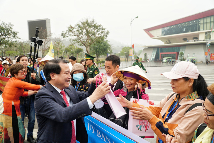 Ông Hà Văn Siêu - phó cục trưởng Cục Du lịch quốc gia Việt Nam - tặng quà cho du khách thăm Việt Nam - Ảnh: NGUYỄN HIỀN
