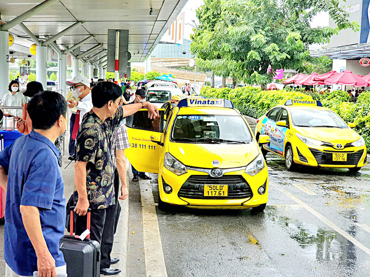 Hành khách đón taxi tại sân bay Tân Sơn Nhất - Ảnh: C.TRUNG