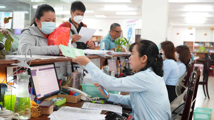 Chuyên viên văn phòng BHXH TP.HCM giải quyết thủ tục hành chính cho người dân - Ảnh: HỮU HẠNH