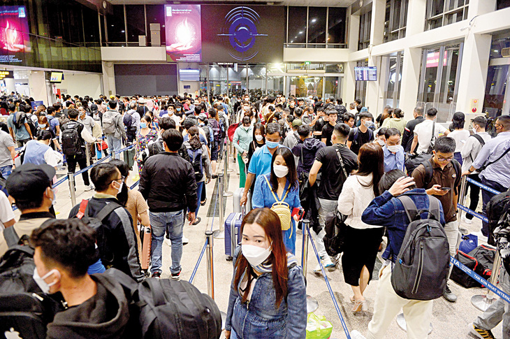 Hành khách xếp hàng chờ đến lượt làm thủ tục an ninh tại sân bay Tân Sơn Nhất, TP.HCM - Ảnh: Q.ĐỊNH