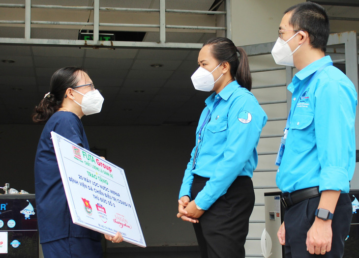 Phan Ngọc Đoan Trang (thứ hai, từ phải qua) đến trao hệ thống lọc nước cho một bệnh viện dã chiến thời điểm dịch COVID-19 bùng phát từ chương trình do báo Tuổi Trẻ kết nối - Ảnh: Q.L.