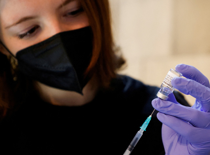 Tình nguyện viên chuẩn bị một ống tiêm có chứa một liều Comirnaty (tên thương mại của vắc xin COVID-19 của Pfizer-BioNTech) tại một trung tâm tiêm chủng ở Nhà thờ St. Stephen, ở Vienna, Áo ngày 5-2-2022 - Ảnh: REUTERS