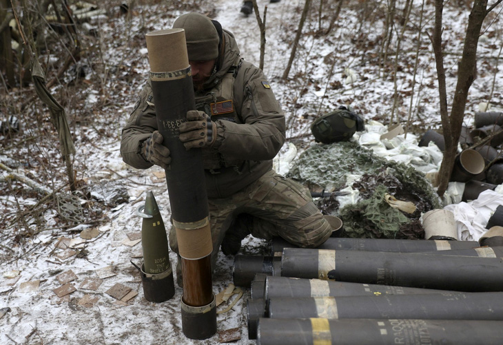 Binh sĩ Ukraine chuẩn bị đạn để khai hỏa lựu pháo L119 về phía các vị trí của Nga tại tiền tuyến ở khu vực Lugansk, đông Ukraine, vào ngày 16-1-2023 - Ảnh: AFP