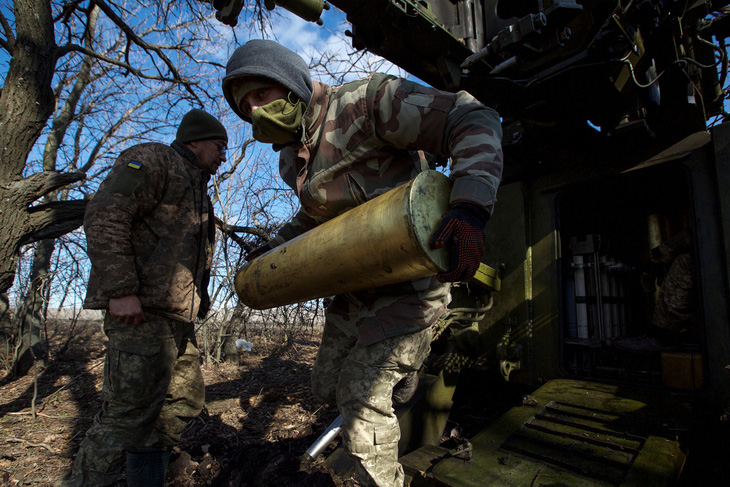 Quân nhân Ukraine mang đạn pháo bắn về phía quân đội Nga bên ngoài thành phố Bakhmut ở Donetsk, Ukraine ngày 5-3-2023 - Ảnh: REUTERS