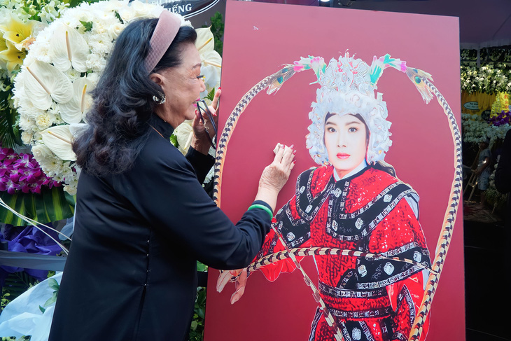Nghệ sĩ Kim Cương bồi hồi xúc động trước ảnh chân dung của nghệ sĩ Vũ Linh - Ảnh: Phạm Thành Trung