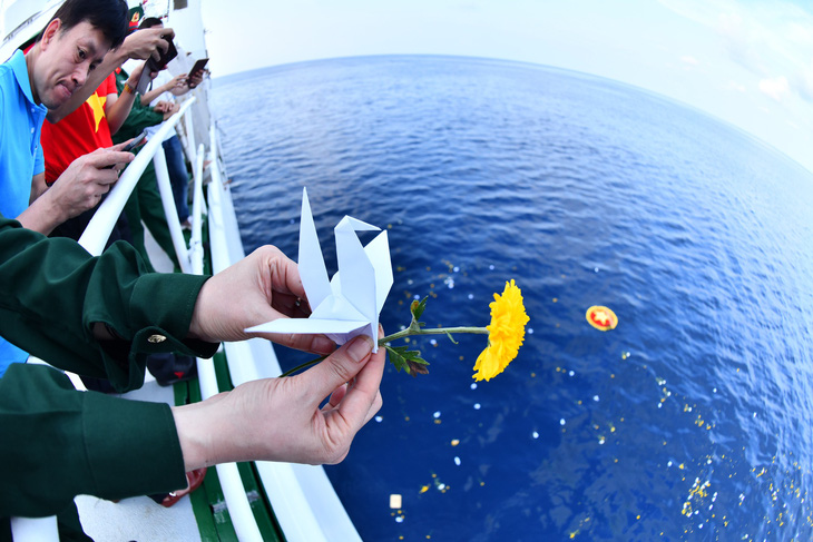 Thả hoa, hạc giấy tưởng niệm các liệt sĩ hy sinh trên vùng biển Cô Lin - Gạc Ma - Ảnh: ĐĂNG KHOA