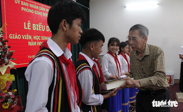 Nhà thơ Thanh Thảo thưởng riêng cho em Hồ Thanh Kỹ, đoạt giải nhất kỳ thi học sinh giỏi cấp tỉnh, cuốn sách Việt Nam sử lược - Ảnh: TRẦN MAI