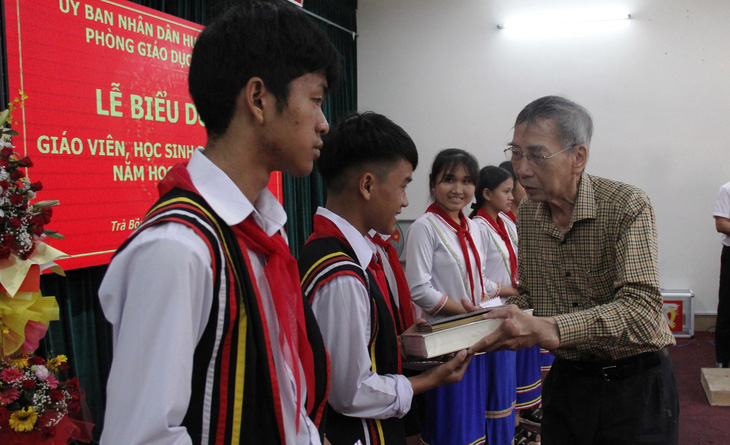 Nhà thơ Thanh Thảo thưởng riêng cho em Hồ Thanh Kỹ, đoạt giải nhất kỳ thi học sinh giỏi cấp tỉnh, cuốn sách Việt Nam sử lược - Ảnh: TRẦN MAI