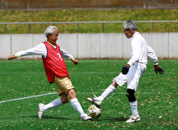 Trong ảnh, tiền vệ Mutsuhiko Nomura (trái) 83 tuổi của đội Sao Đỏ đang tranh chấp bóng với thủ thành Hiroshi Nishino 87 tuổi của đội Hawai Xanh trong trận khai mạc giải bóng đá SFL (Soccer For Life) 80 League dành cho các cầu thủ độ tuổi từ 80 trở lên tại Tokyo, Nhật Bản hôm 12-4 vừa qua - Ảnh: REUTERS