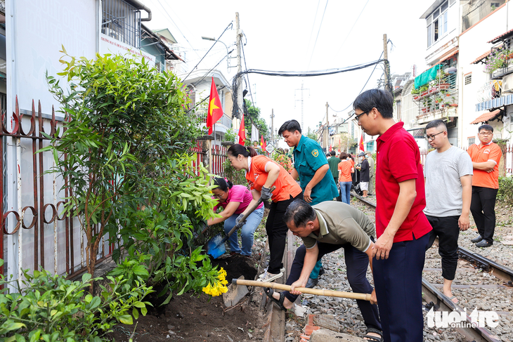 Cán bộ công chức - viên chức, dân quân, nhân dân phường 4, quận Phú Nhuận dọn vệ sinh, trồng hoa dọc tuyến đường sắt qua địa bàn - Ảnh: T.B.T.