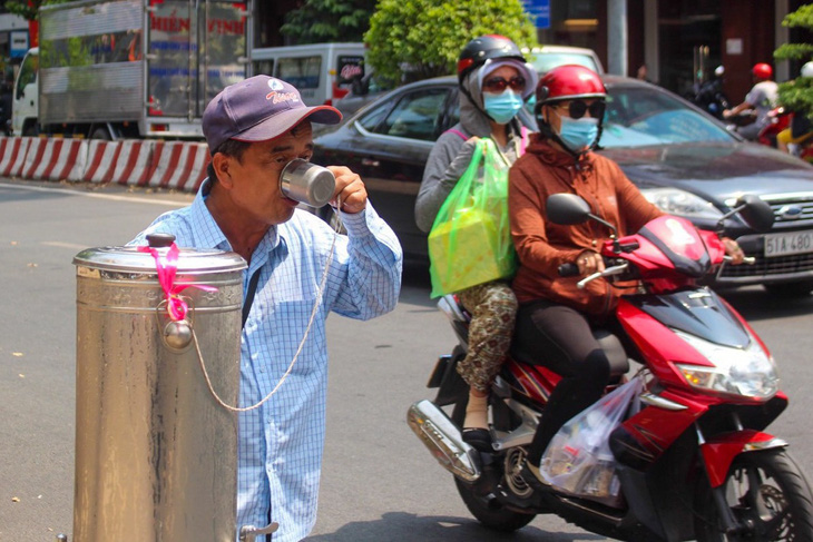 Người dân TP.HCM uống nước dưới trời nắng gắt - Ảnh: LƯU DUYÊN