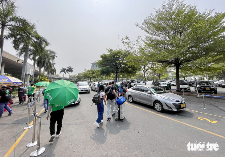 Đổi chỗ đón xe công nghệ ở Tân Sơn Nhất, khó khăn cho dân lẫn tài xế - Ảnh 1.