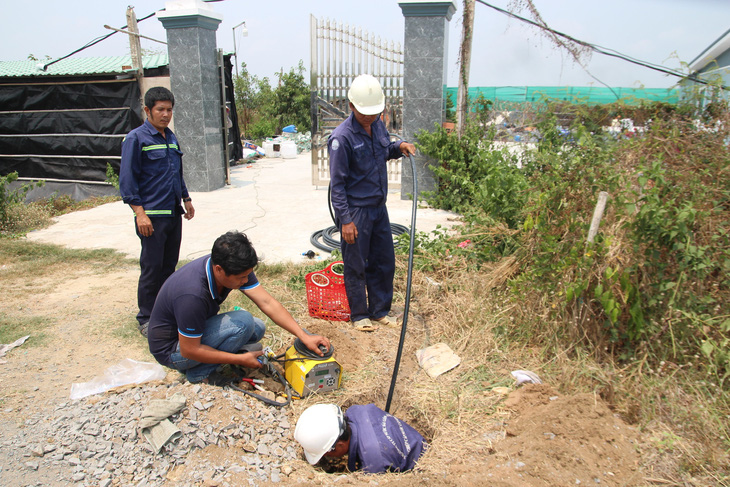 Nhân viên Xí nghiệp Cấp nước Cần Giờ lắp đặt đồng hồ nước cho các hộ dân