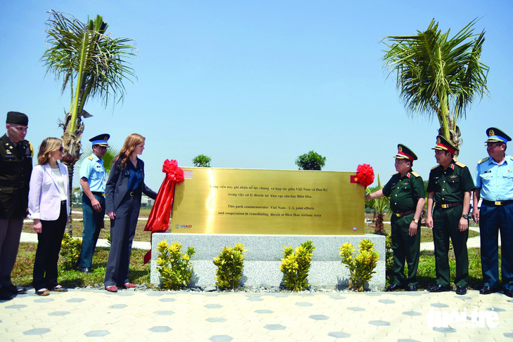 Phái đoàn USAID và đại diện phía Việt Nam bên cạnh bia kỷ niệm xử lý xong dioxin ở khu vực 3ha thuộc sân bay Biên Hòa cũ, tháng 3-2023. Ảnh: A Lộc