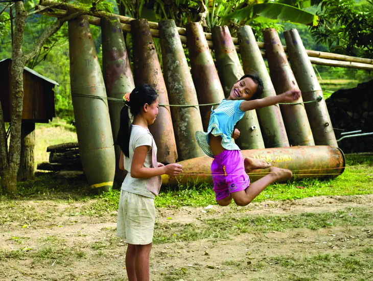 Trẻ em ở Lào chơi đùa bên cạnh những quả bom còn sót lại thời chiến. Ảnh: Getty Images