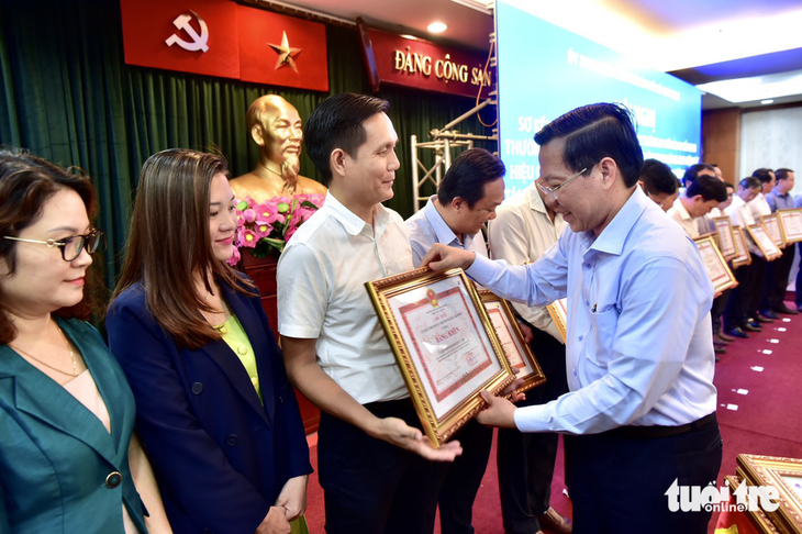 Chủ tịch UBND TP.HCM Phan Văn Mãi tặng bằng khen cho đại diện báo Tuổi Trẻ - Ảnh: LÊ PHAN