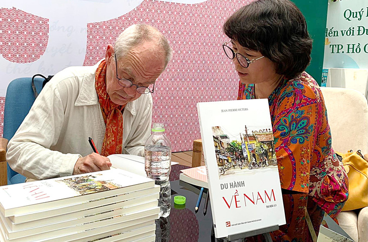 Tác giả Jean-Pierre Outers (trái) ký tặng sách Du hành về Nam tại Đường sách TP.HCM - Ảnh: KHẢ LINH